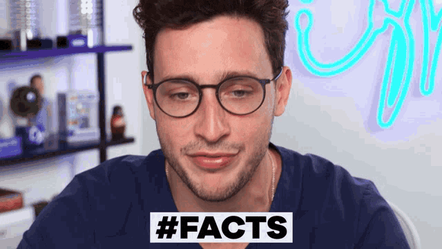 a man wearing glasses and a blue shirt with the words #facts on the bottom