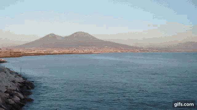 a large body of water with mountains in the background and the website gifs.com in the corner