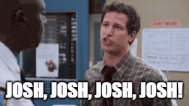 a man in a plaid shirt and tie is talking to another man in a police department .