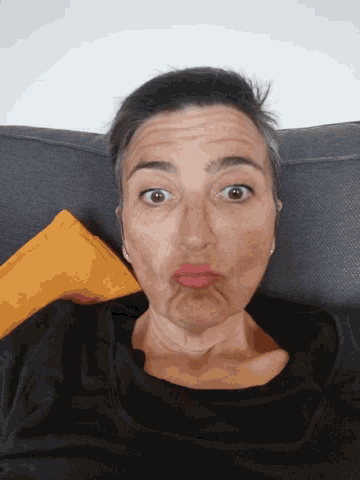 a woman laying on a couch making a face