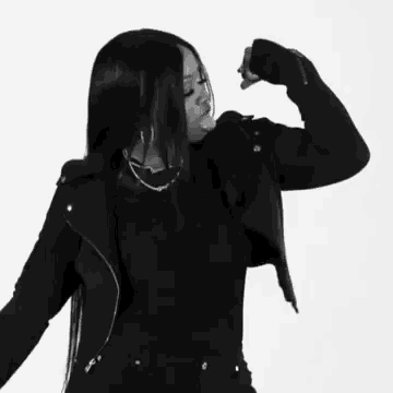 a black and white photo of a woman flexing her arms