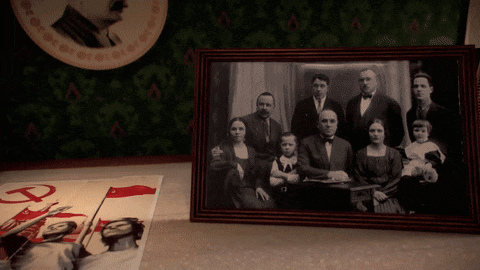 a framed picture of a family with a red r on the bottom right
