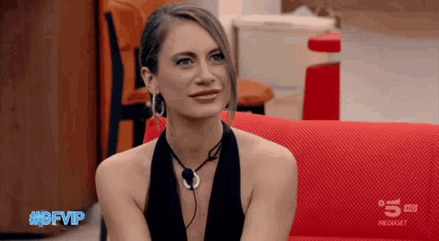 a woman sitting on a red couch with gfvip written on the bottom of the screen
