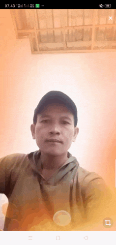 a man taking a selfie on his phone with the time of 07.43