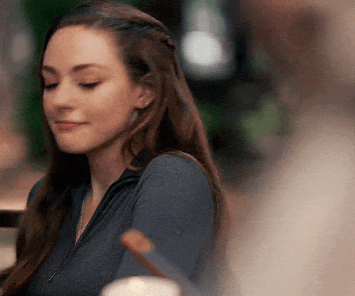 a close up of a woman 's face with her eyes closed and a braid in her hair .