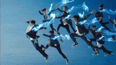 a group of people are jumping in the air with blue smoke coming out of them