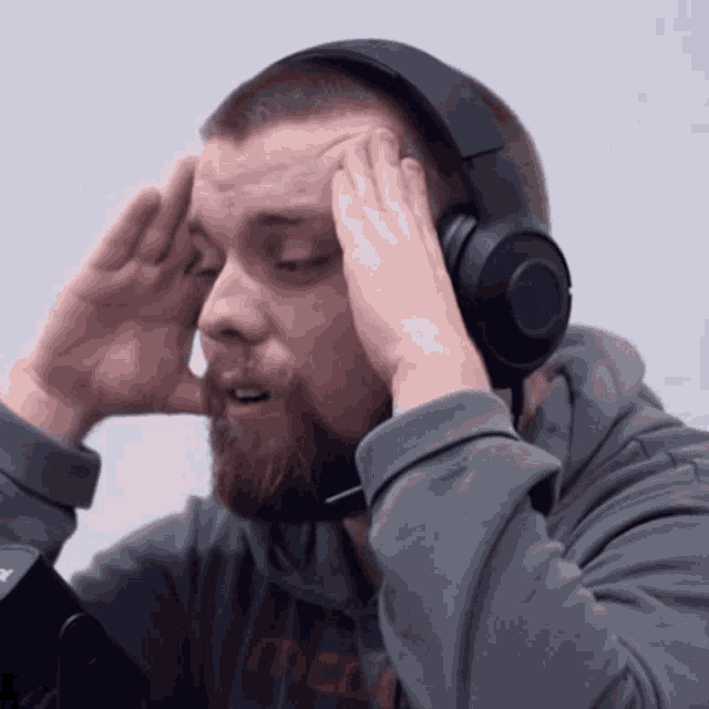 a man with a beard wearing headphones and a sweatshirt that says t.c.l.