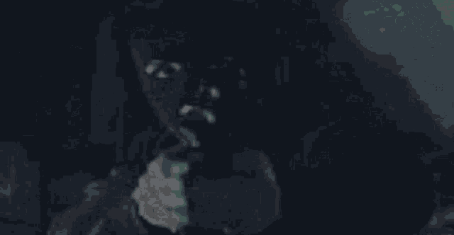 a blurry picture of a man 's face in a dark room with a blue sky in the background