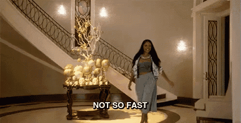 a woman is walking down a staircase in a room with the words `` not so fast '' written on it .