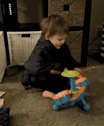 a little boy is playing a toy drum set