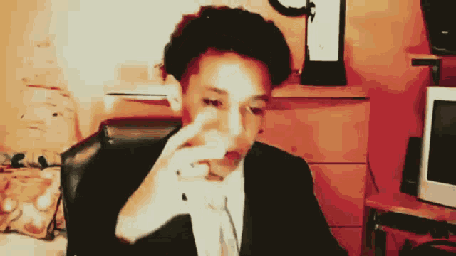 a man in a suit is sitting in front of a computer screen