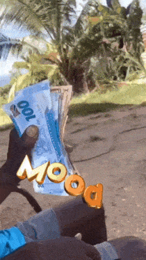 a person is holding a stack of 100 bills in their hand