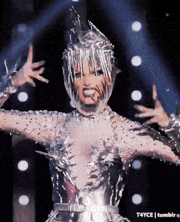 a woman in a silver costume is dancing on a stage with t4yce tumblr in the corner