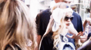 a group of people are standing next to each other in a crowd .
