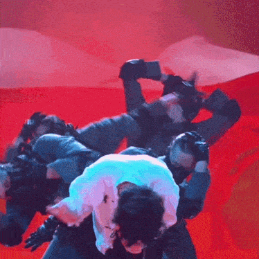 a man in a white shirt is being lifted by a man in a black suit on a stage