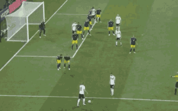 a group of soccer players are playing on a field with a goalie in the background
