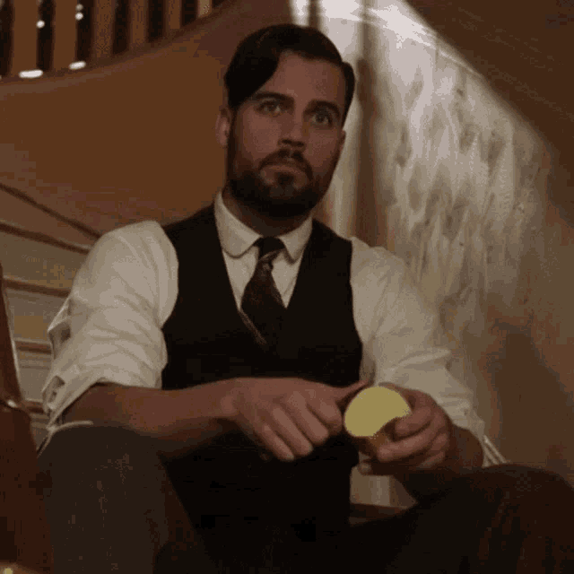 a man in a suit and tie is sitting on the floor