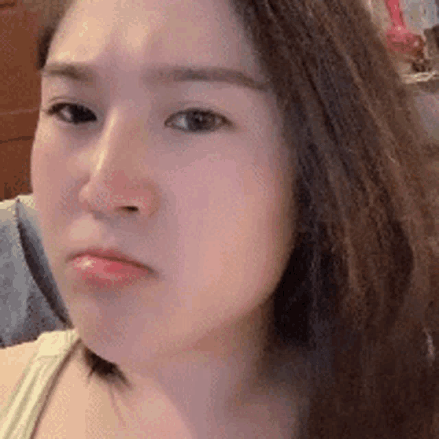a close up of a woman 's face with a sad expression .