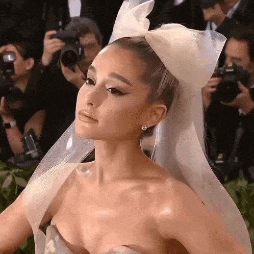 a woman in a white dress with a bow in her hair