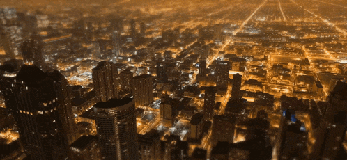 an aerial view of a city at night with a clock tower that says ' chicago ' on it
