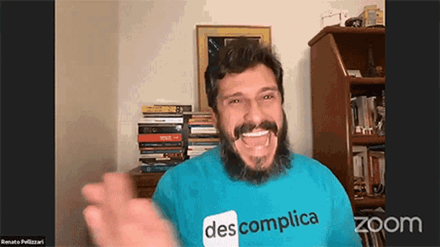 a man with a beard wearing a blue shirt with the word des complicata on it
