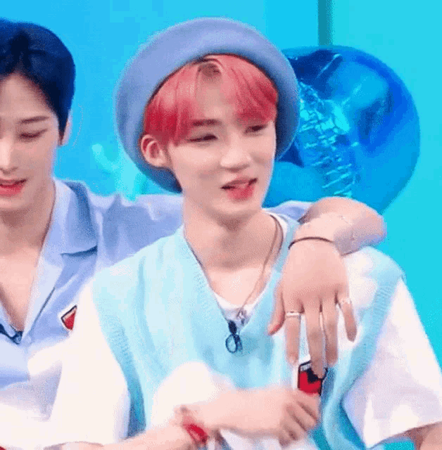 a man with red hair is sitting next to another man with blue hair .