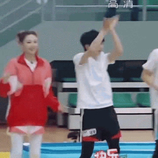 a man and a woman are standing next to each other on a trampoline .