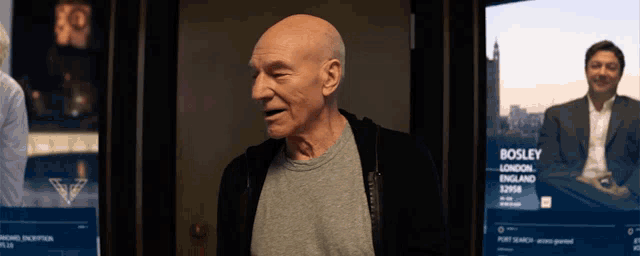 a bald man is standing in front of a screen that says bosley