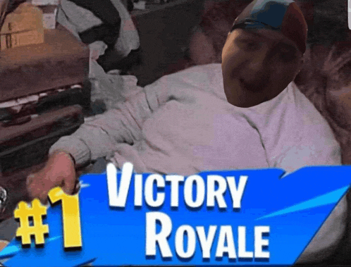 a man laying on a couch with a sign that says victory royale # 1