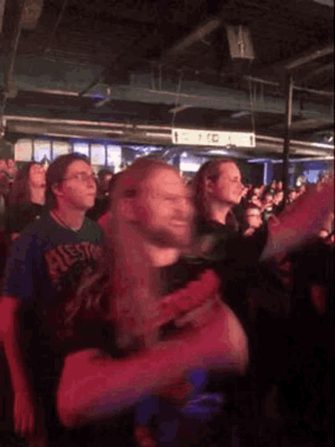 a crowd of people are dancing in a dark room .