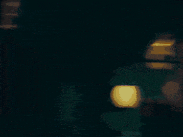 a blurred image of a person standing in front of a light that says ' coca cola ' on it