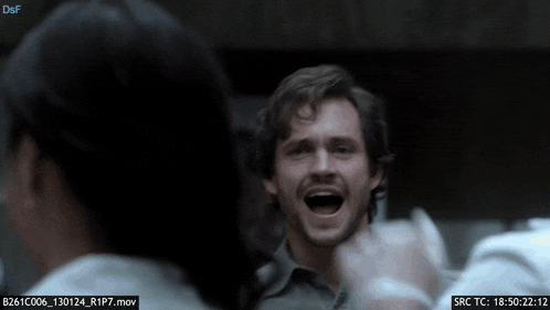 a man with his mouth open is surrounded by people and a screen says src tc