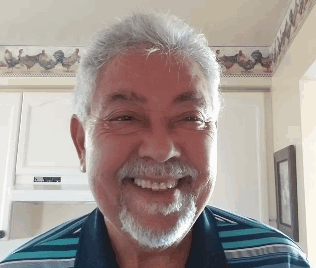 a man with a beard is smiling in front of a microwave oven