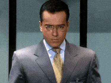 a man wearing a suit and tie has a name tag in his pocket