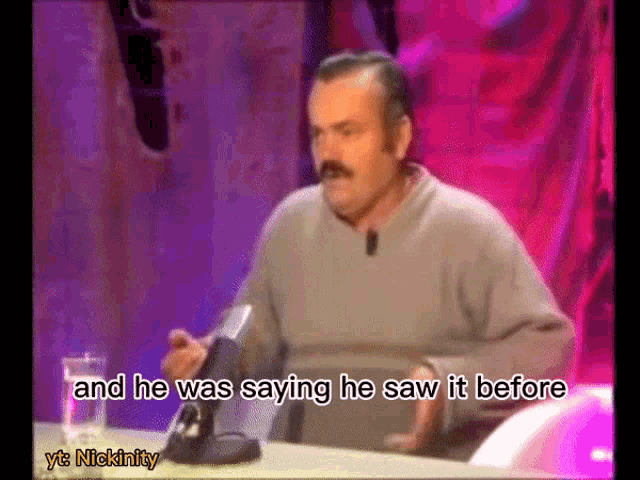 a man is sitting at a table with a microphone and he was saying he saw it before nickinity