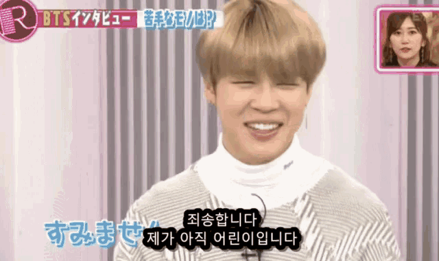 a man is smiling in front of a sign that says ' bts '