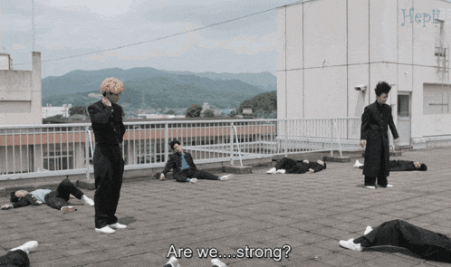 a group of people are laying on a roof and one of them is asking are we strong