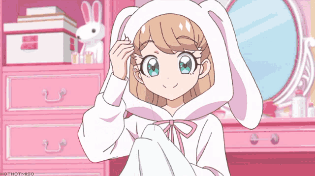 a girl with bunny ears is sitting in front of a mirror