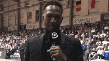 a man is holding a microphone with the letter b on it