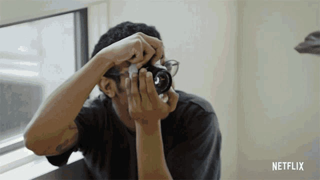 a man is taking a picture with a netflix logo in the background