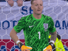 a soccer player wearing a number 1 jersey stands in front of a net