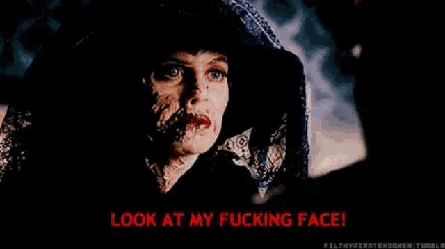 a woman with a hood on her head is looking at her face and saying `` look at my fucking face '' .