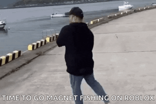 a man is standing on a pier looking at the water .