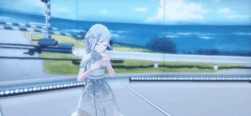 a girl in a white dress is standing on a stage in front of a ocean .