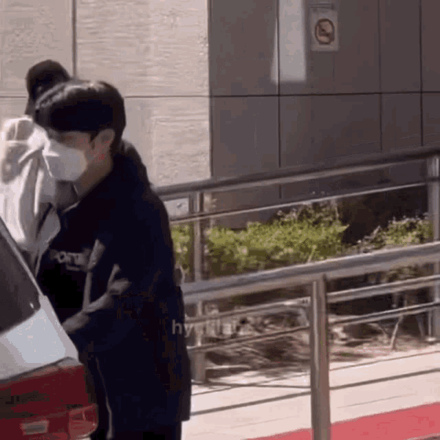 a man wearing a mask is pushing a car