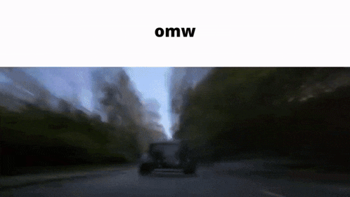 a blurry picture of a car driving down a road with the word omw on the top