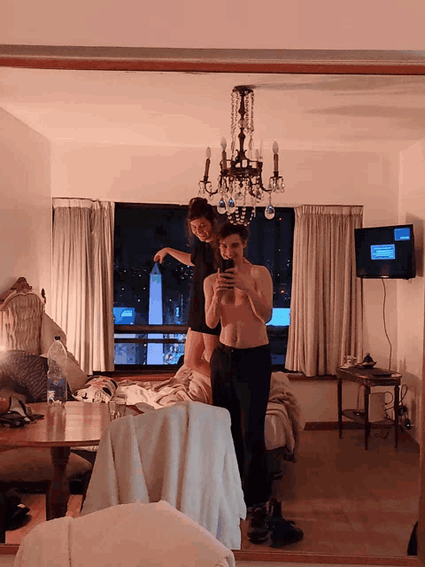 a man and a woman are taking a picture in a bedroom