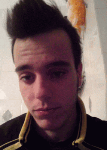 a close up of a man 's face with a black and yellow shirt