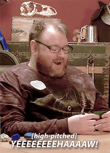 a man with a beard wearing glasses and a shirt that says high pitched yeeeeeehaaaw