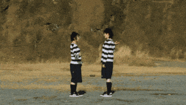 two people standing next to each other in striped shirts